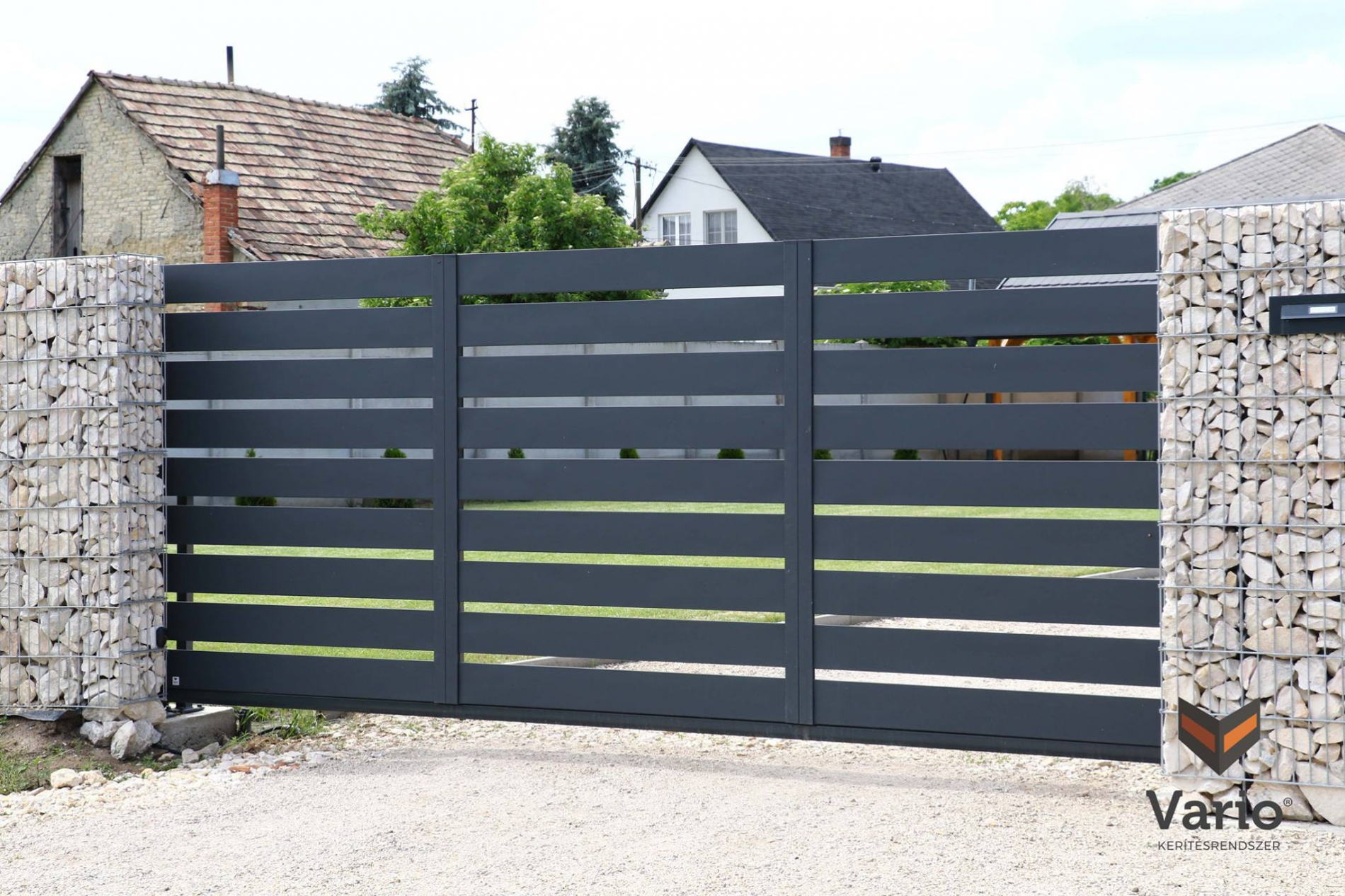 Nyitott típusú kerítésünk, 16cm-es, antracit színű (RAL7016) elemekkel, 3 cm-es hézaggal, gabion oszlopok között